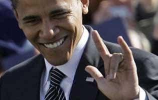 Man in dark suit smiling and waving