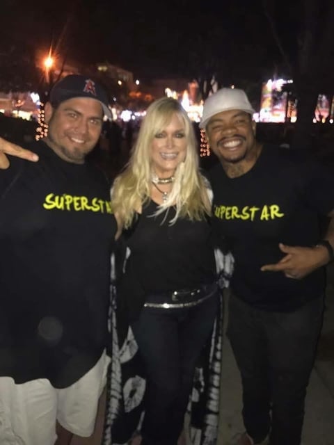 Three people smiling at night event