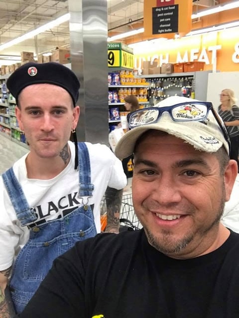 Two men smiling for a selfie in grocery store